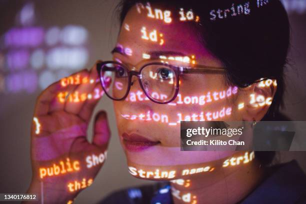 portrait of  female programmer with program code projected on her face - projection equipment stockfoto's en -beelden