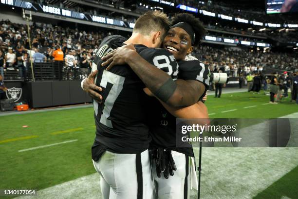 Foster Moreau of the Las Vegas Raiders hugs Henry Ruggs III after the Las Vegas Raiders defeat the Baltimore Ravens 33-27 in overtime at Allegiant...