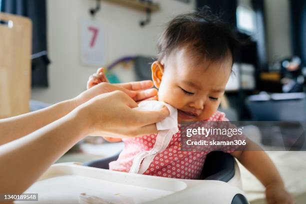 close up facial expression asian baby enjoyment  eating first meal  at home domestic life - sorry funny stock pictures, royalty-free photos & images