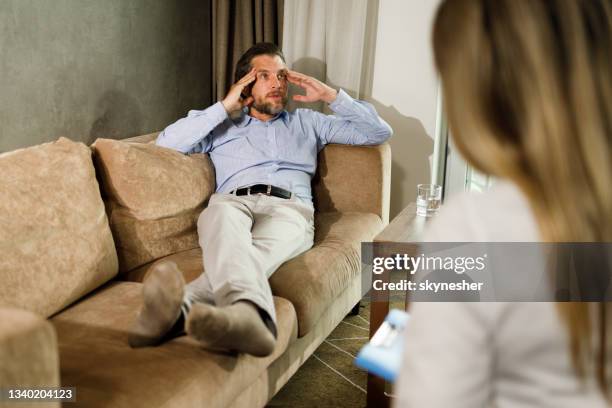 worried businessman having a therapy at psychiatrist's. - psychiatrist's couch stock pictures, royalty-free photos & images