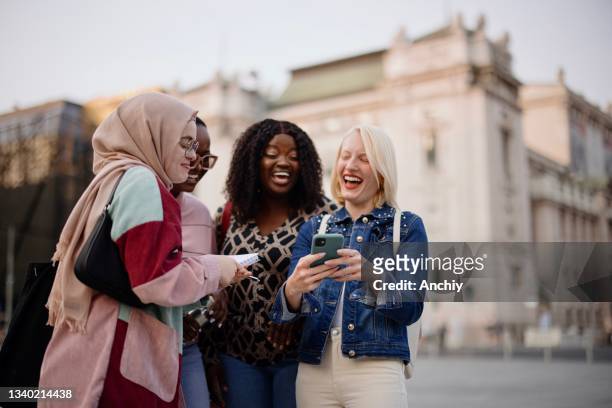 multiethnic friends watch funny memes on the smartphone in the city streets - big fat white women stock pictures, royalty-free photos & images