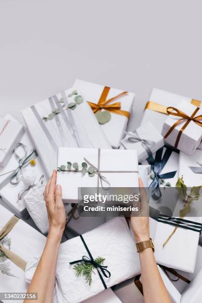 top view of female hands holding christmas present - pile of gifts stock pictures, royalty-free photos & images