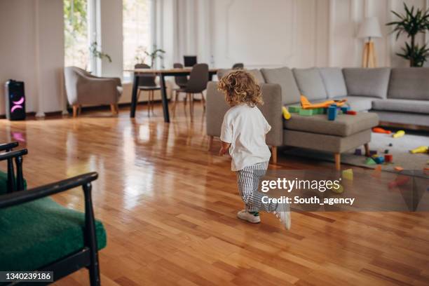 little boy playing in living room - running indoors stock pictures, royalty-free photos & images