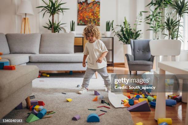 little boy playing in living room - messy room stock pictures, royalty-free photos & images