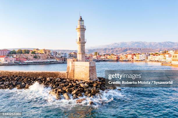 waves crashing on lighthouse, chania, crete, greece - kreta stockfoto's en -beelden