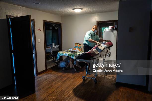 Funeral home worker covers the body of a woman who died at home of Covid-19, before transporting her on September 13, 2021 in Houston, Texas. She had...