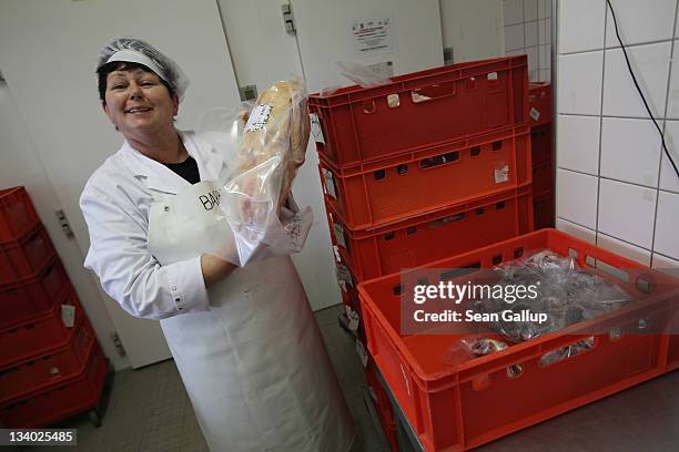 Employee Babara Schneider holds up a just-packaged, feshly-slaughtered goose for delivery at the Oekohof Kuhhorst organic farm near Berlin on...