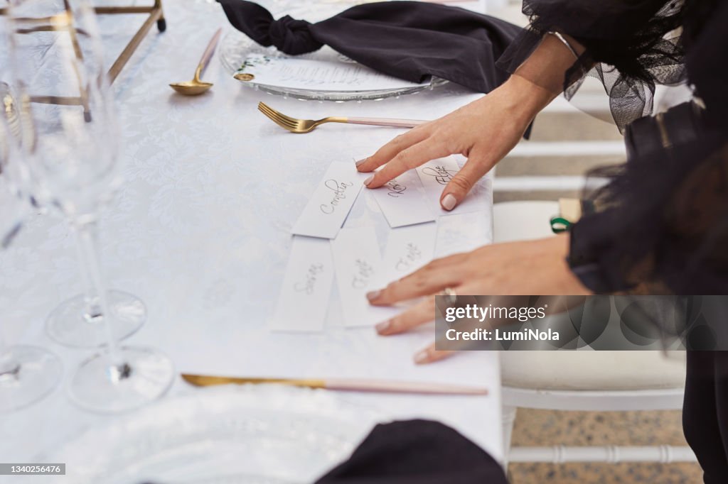 Scatto di una donna irriconoscibile che decora un tavolo con segnaposto in preparazione di un ricevimento di nozze