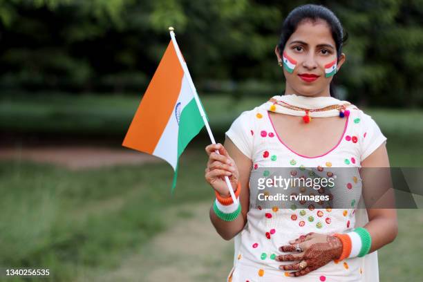 young indian woman holding national flag of india - india flag stock pictures, royalty-free photos & images