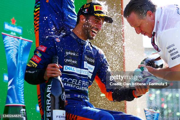 Daniel Ricciardo of Australia and McLaren celebrates with a shoey on the podium as McLaren CEO Zak Brown pours the sparkling wine following his...