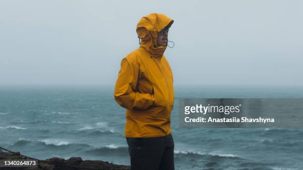 man traveler walking at the stormy beach feeling awe in iceland - snow wind stock pictures, royalty-free photos & images
