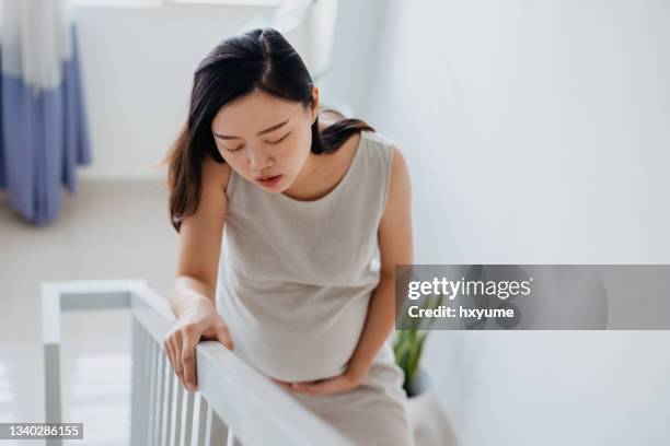 müde schwangere frau, die treppen steigt - asian woman pregnant stock-fotos und bilder