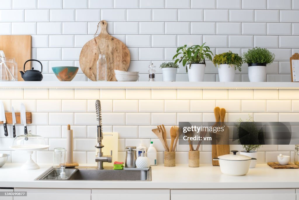 Moderno novo interior de cozinha leve com utensílios, decoração e panelas com ervas