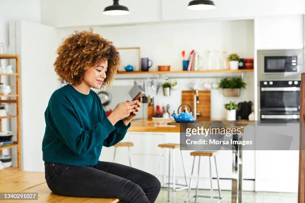 african american woman surfing social media at home. - gente mirando moviles fotografías e imágenes de stock