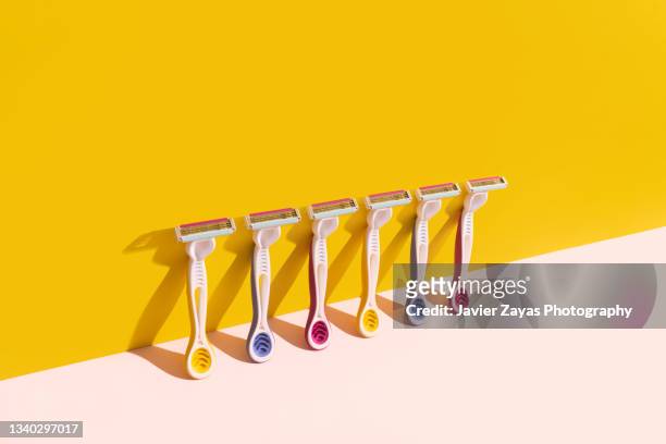 six razor blades on yellow/pink background - scheermes stockfoto's en -beelden