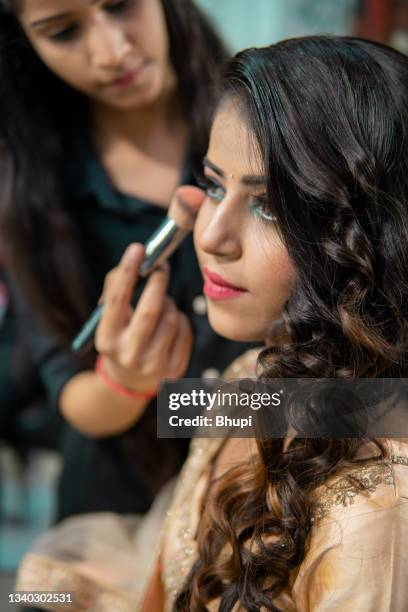 schöne indische frau bereitet sich auf eine hochzeitsfeier im schönheitssalon vor. - salon reception stock-fotos und bilder