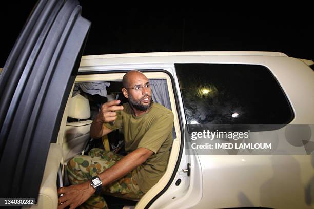 Saif al-Islam Kadhafi, son of Libyan leader Moamer Kadhafi, appears in front of supporters and journalists at his father's residential complex in the...