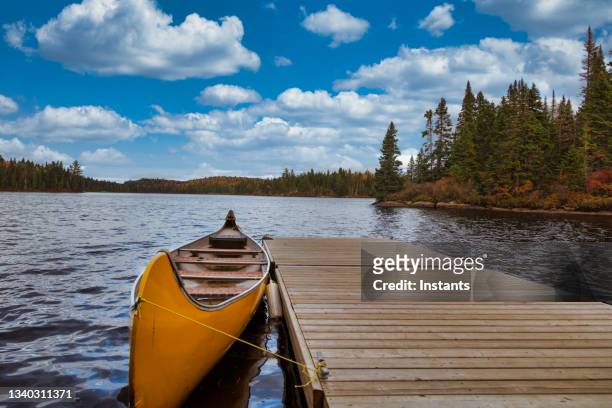 orange yellow canoe on a lake. - moored stock pictures, royalty-free photos & images