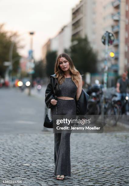 Sonny Loops wearing a black leather jacket, grey two piece and a black prada mini bag on September 11, 2021 in Berlin, Germany.