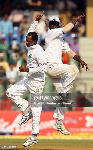 West Indies bowler Marlon Samuels celebrates with captain Drren Sammy after taking the wicket of Indian batsman Rahul Dravid during the third day of...