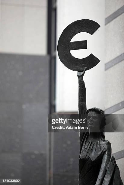The "Europe" sculpture by Belgian artist May Claerhout, showing a woman holding up the symbol of the Euro, stands outside the European Parliament...
