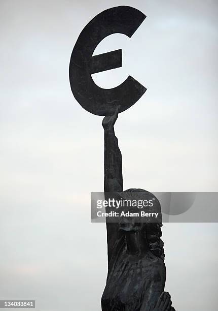 The "Europe" sculpture by Belgian artist May Claerhout, showing a woman holding up the symbol of the Euro, stands outside the European Parliament...