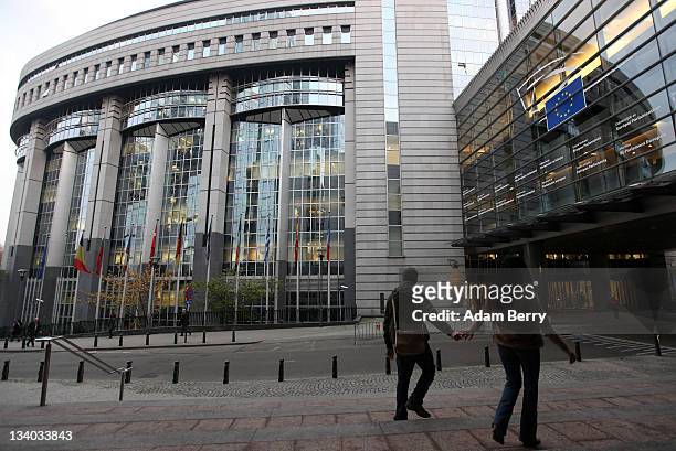 Visitors pass the Paul-Henri Spaak building of the European Parliament, where extraordinary sessions of the political body are held, as well as the...