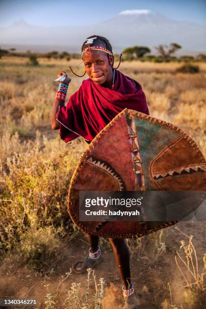 warrior from maasai tribe, mount kilimanjaro on background, kenya, africa - masai warrior stockfoto's en -beelden