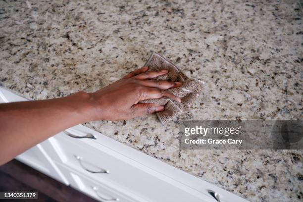 woman wipes kitchen counter - vod stockfoto's en -beelden