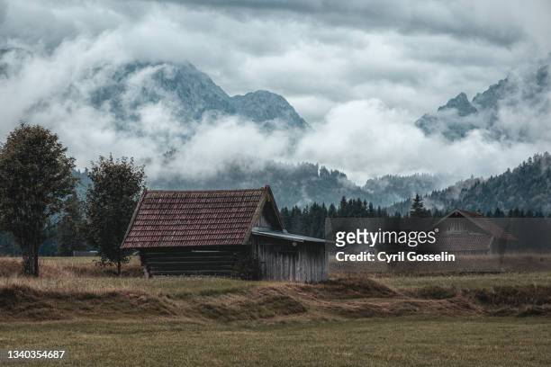 moody shots of cabins in a valley of the bavarian alps - entsättigt stock-fotos und bilder