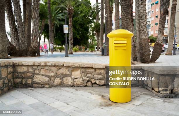 yellow mailbox for sending letters at a public park of a city. - yellow envelope stock pictures, royalty-free photos & images