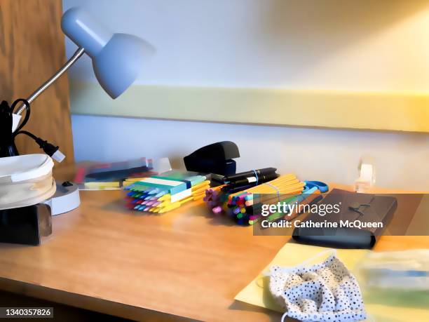 moving day: student desk in dorm room with school supplies, protective face mask & covid-19 testing kits in plastic bag - dorm room stock pictures, royalty-free photos & images