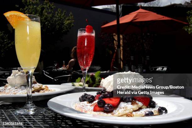 Boston, MA-- Blueberry and strawberry compote pancakes, back right, with a mimosa and kir royal at the Blarney Stone patio Thursday.