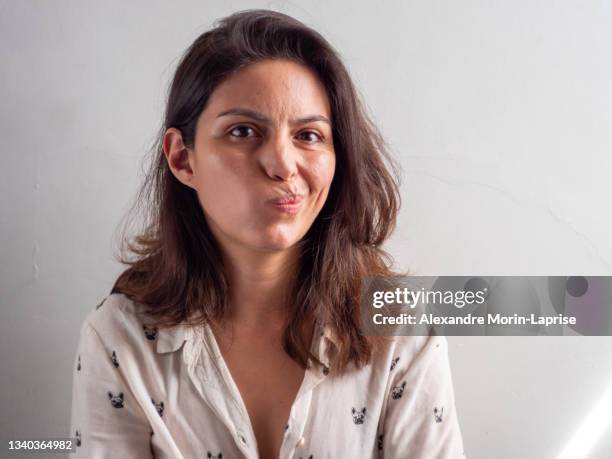 brown hair peruvian woman looks unsure about a decision - awkward stockfoto's en -beelden