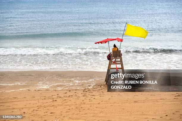 rear view of unrecognizable woman working as life guard at costline of a beach - beach lifeguard bildbanksfoton och bilder