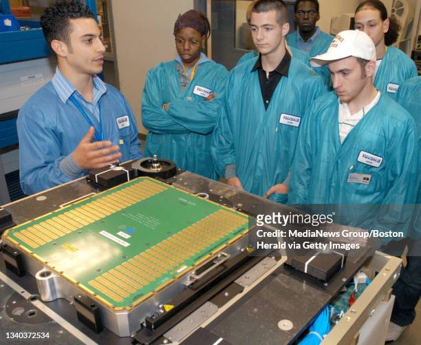North Reading, MA-- Test engineer Peter Romano, left, shows off an automated tester to a group of students participating in "High Tech U" Wednesday...