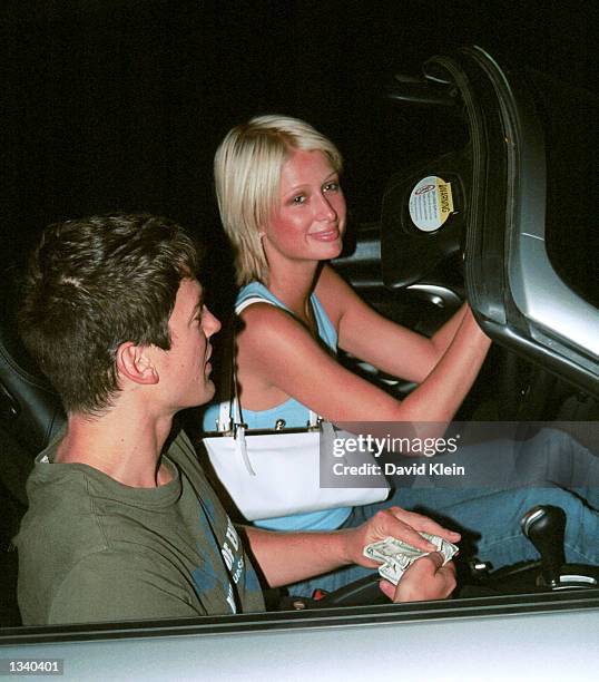 Model Paris Hilton and unidentified friend pose outside The Lounge club on August 15, 2002 in West Hollywood, California.