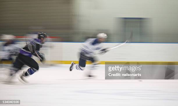 two ice hockey players making a break for the puck - ice hockey stockfoto's en -beelden