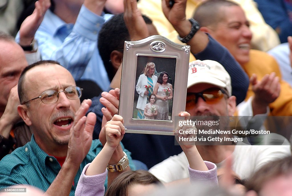 (5/17/05 - Boston, MA ) Laura Carr Frustaci of Burlington holds a photo of her moms, Maureen Carr and Joanne Frustaci as crowds celebrate the first anniversary of the legalization of gay marriage on the Boston Common in front of the State House Tuesd