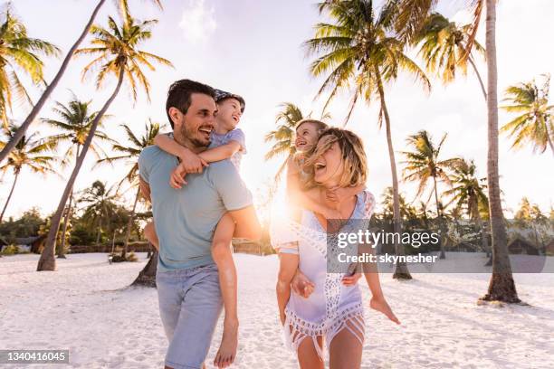 carefree family having fun while piggybacking on the beach. - ilha de zanzibar imagens e fotografias de stock