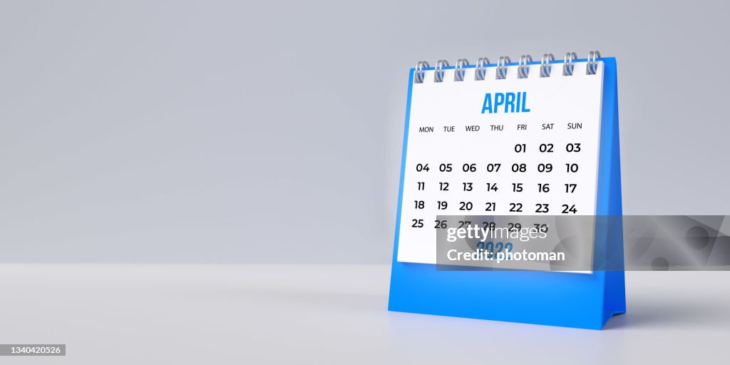 Blauer April-Schreibtischkalender 2022 auf leerem Hintergrund mit Kopierraum.