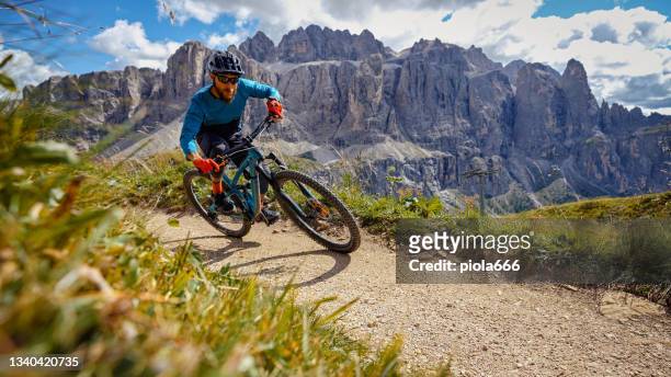 mtb mountain biking outdoor on the dolomites:enduro discipline over a single trail track - mountain biker stock pictures, royalty-free photos & images