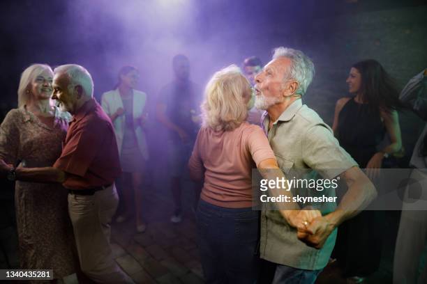happy mature couples dancing in a disco. - night club stock pictures, royalty-free photos & images