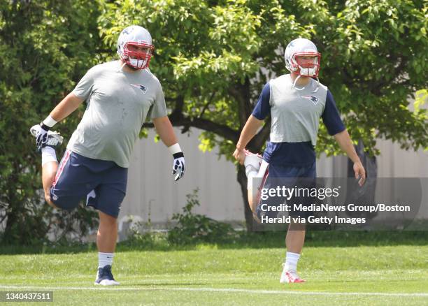 Patriots offensive lineman Josh Kline and wide receiver Julian Edelman warm up for OTA workouts on the upper grass fields at Gillette Stadium on...