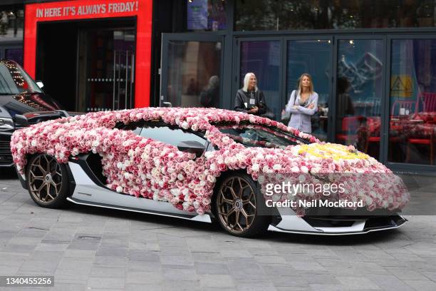 A Lamborghini sports car covered in roses outside Global Radio