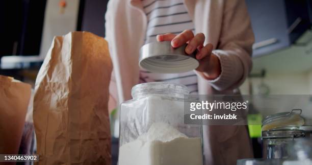 woman is organizing food in her kitchen pantry - flour bag stockfoto's en -beelden