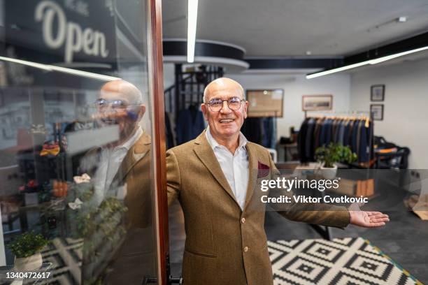 senior men open the door at men's clothing store - boutique entrance stock pictures, royalty-free photos & images