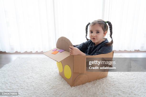 little girl having fun with cardboard box - cardboard car stock pictures, royalty-free photos & images