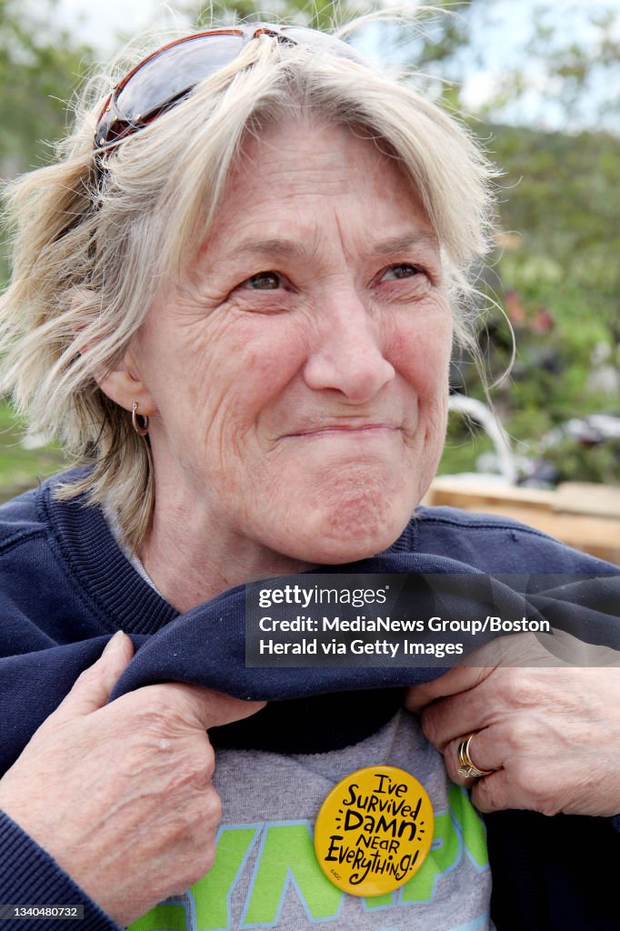 (060211 Monson, MA) Debbie Meacham shows off a button saying, "I've survived damn near everything," that she found in the tornado-flattened rubble of her Bethany Road home, Thursday, June 02, 2011. Staff photo by Angela Rowlings.