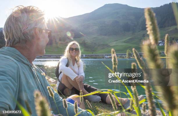 mountain hiking couple relax near lakeshore - people speaking great background stock pictures, royalty-free photos & images